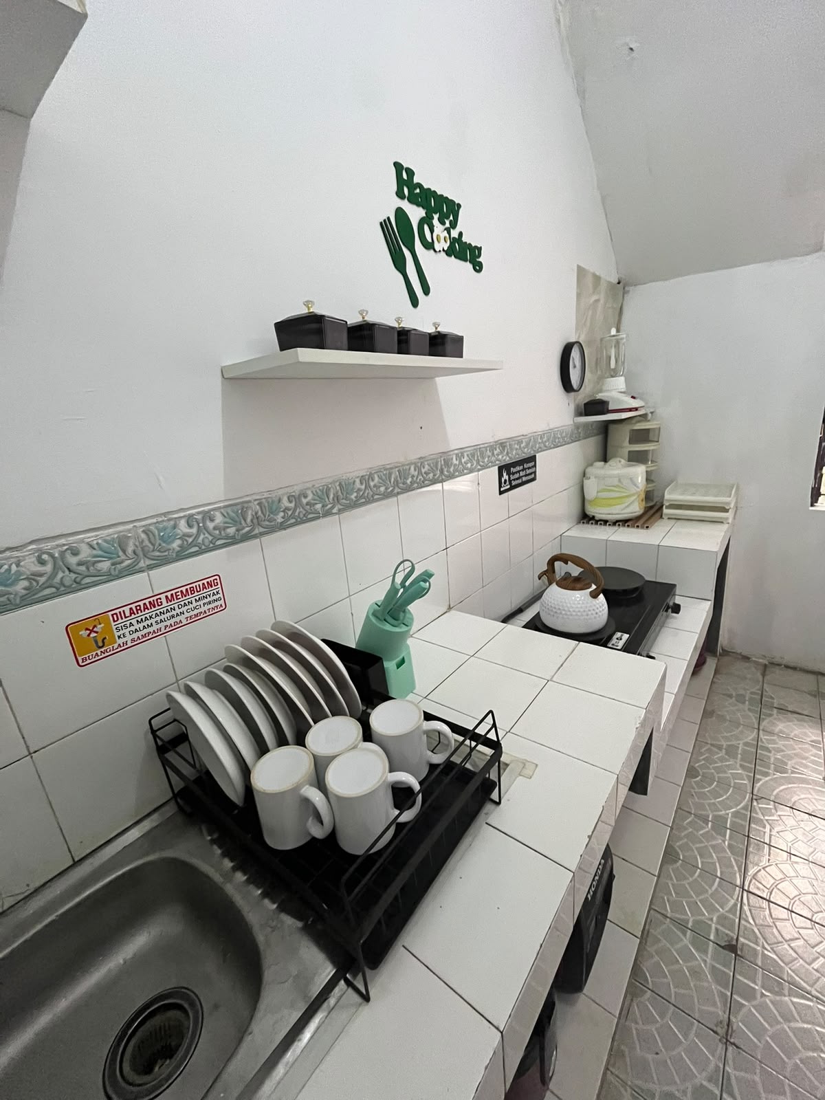 Dapur modern bersih dengan kompor, peralatan masak, dispenser air dan ruang makan keluarga