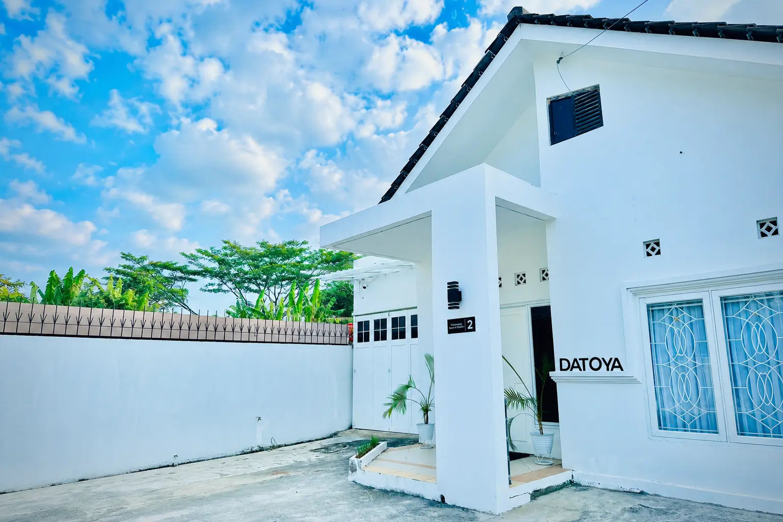 Tampak depan modern DATOYA Guest House di Semarang dengan lanskap hijau asri