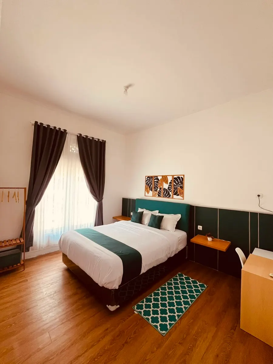 Sudut kamar utama DATOYA Guest House dengan tata ruang rapi dan pencahayaan hangat