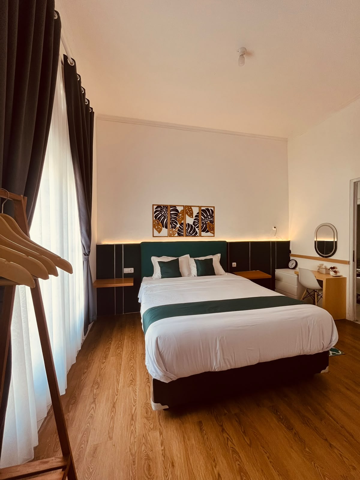 Kamar tidur utama premium DATOYA Guest House dengan sprei putih bersih dan pencahayaan hangat